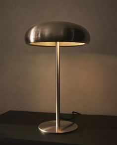 a table lamp sitting on top of a black counter next to a white wall and floor