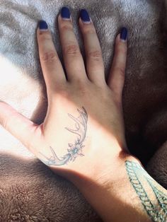 a woman's hand with a deer tattoo on her left wrist and the other arm