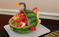 a watermelon carved to look like a fruit bowl with strawberries and bananas