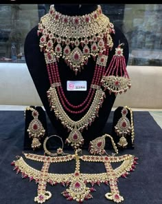 an elaborate necklace and earring set on display in a store window with other jewelry items