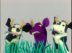 three cartoon cows standing in the grass with their heads turned to look like they are talking