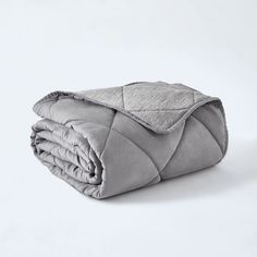 a blanket is folded on top of a white surface