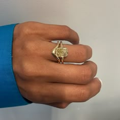 a woman's hand with a yellow diamond ring on top of her left hand