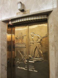 the door to an elevator is etched with a man holding a baseball bat and standing in front of it