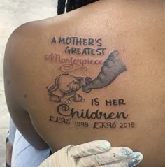 the back of a woman's shoulder with an elephant tattoo on her left side