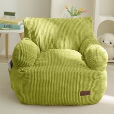 a green corded chair with a stuffed animal sitting on it's side table