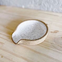 a white and brown bowl sitting on top of a wooden table