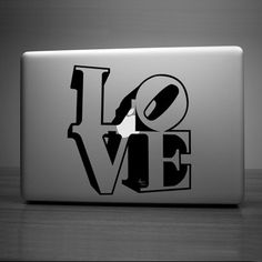 an apple laptop with the word love on it's cover in black and white