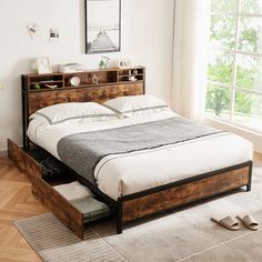 a bed sitting on top of a hard wood floor next to a wooden dresser under a window