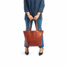 Our classic tote is handcrafted in luxuriously soft, vegetable-tanned American leathers. Spacious, durable, and versatile this tote is ideal for everyday use. For added security, the tote features a large zip-top canvas pouch that snaps in at the sides and can be removed for easy cleaning. A drop-in pocket holds your phone, keys and other small items. Easily convert the tote to a crossbody bag by clipping the optional strap into interior D rings. Crafted by artisans for a lifetime of daily use, the Range Tote features premium metal hardware and elegant finished edges. It can accommodate a laptop up to 14 inches. Our leathers are carefully selected for their natural appearance and regenerative sourcing -- they come from rangelands managed in alignment with nature. Variations in tone, marks Elegant Cognac Bag For On-the-go, Brown Bag With Top Carry Handle For Everyday Use, Elegant Bags With Leather Lining For On-the-go, Versatile Bucket Bag With Leather Lining For Everyday Use, Brown Bags With Top Carry Handle For Everyday Use, Everyday Brown Bags With Top Carry Handle, Brown Everyday Bags With Top Carry Handle, Classic Box Bag With Leather Handles For Everyday, Classic Handheld Bags For On-the-go