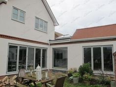 an outside view of a house with patio furniture in the foreground and back yard