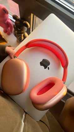 an apple headphone sitting on top of a white box next to a pink stuffed animal