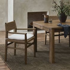 a wooden table with two chairs and a potted plant on top of the table