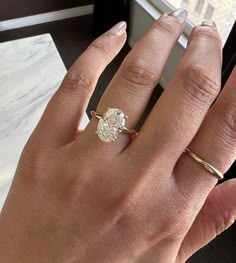 a woman's hand with a ring on it and a diamond in the middle