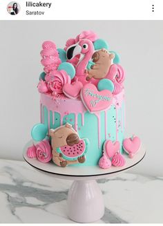 a pink and blue cake with flamingos on top