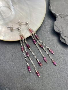 Intricately wire-wrapped onto a delicate sterling silver chain, these earrings feature tiny pink Tourmaline gemstones. With lightweight design and sterling silver posts, they offer all-day comfort. Adding an elegant touch, a cascade of tiny sapphire stones enhances the beauty of these versatile earrings, suitable for any occasion. Dress them up or down effortlessly. EARRING FEATURES Total Length: 2.5 inches Metal: .925 Sterling Silver  Closure: 3mm Ball Posts (.925 stamped for authenticity) Gems Delicate Silver Jewelry With Dangling Beads, Sterling Silver Jewelry With Dangling Beads, Sterling Silver Earrings With Dangling Beads For Gifts, Sterling Silver Wire Wrapped Linear Earrings As Gift, Dainty Pink Wire Wrapped Jewelry, Sterling Silver Linear Earrings With Dangling Beads For Gift, Sterling Silver Gemstone Linear Earrings As Gift, Sterling Silver Wire Wrapped Linear Earrings For Gifts, Sterling Silver Dangle Linear Earrings With Gemstones