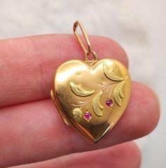 This exquisite locket, made in France from 18-carat gold, is a true treasure and a fine example of late 19th to early 20th-century jewelry craftsmanship. It bears the eagle's head hallmark, confirming the use of high-quality gold. The heart-shaped locket weighs 3.08 grams and measures 2 cm by 2 cm.  The hinges of the locket are broken, but it still closes securely and stays in place. It is adorned with a delicate branch made of green gold and features two natural rubies. The two natural rubies n Art Nouveau Locket, Wedding Locket, Bijoux Art Nouveau, Sentimental Jewellery, Gold Heart Locket, Vintage Wedding Gifts, French Art Nouveau, Antique Locket, Beautiful Symbols