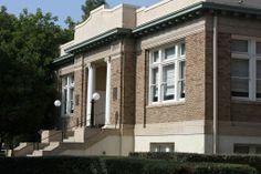 an old brick building with white trim on the front door and stairs leading up to it