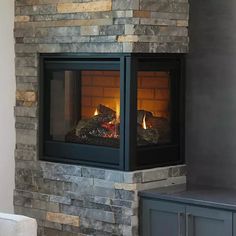 a fireplace in a living room with a tv on the wall and windows above it