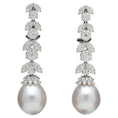 An elegant pair of pearl and diamond dangle earrings. 1.50 carats of white round brilliant cut diamonds set into round and marquise shapes with a pearl drop. 18k white gold Approximately 1.6 inches long A timeless pair of earrings! White Diamond Pearl, White Gold Drop Earrings, South Sea Pearls Earrings, Diamond Cluster Earrings, White Pearl Earring, Pearl And Diamond Earrings, Diamond Dangle Earrings, Diamond Chain, White Jewelry