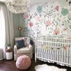 a baby's room with a floral wallpaper and white crib in the corner