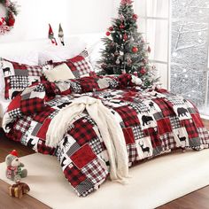 a christmas themed bedroom with red and black plaid comforter, white bedding and trees