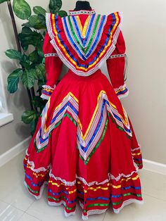 Step into the spotlight with our Beautiful Women's Jalisco Dress, a culturally inspired costume that embodies the spirit of Mexico. Handmade with love and attention to detail, this dress comes with 3 color satin ribbons in yellow, royal blue,  and green to add a pop of color to your ensemble.  Overview: Available in sizes S, M, and L, with bust lines ranging from 34-44" and skirt lengths from 24-34", this dress is a timeless piece for any celebration.  Delivery times: Please allow 2-3 weeks for Multicolor Carnival Costume Dress, Traditional Multicolor Fiesta Dress, Traditional Multicolor Dress For Fiesta, Traditional Fitted Costume Dress, Fiesta Fitted Dresses For Festivals, Traditional Dress For Fiesta And Festivals, Traditional Fitted Dress For Cinco De Mayo, Fitted Dresses For Fiesta And Festivals, Multicolor Folk Dress For Fiesta