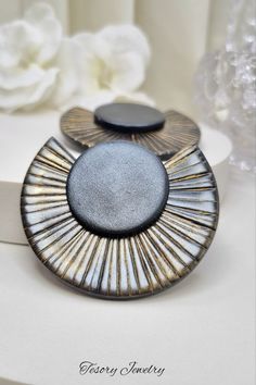 two black and white plates sitting on top of a table with flowers in the background