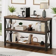 a shelf with books, plants and pictures on it