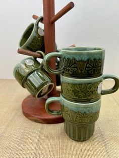 four green coffee mugs stacked on top of each other