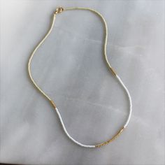 Our lithe necklace is handcrafted with a touch of gold in a minimalist style. •Seed beads in your choice of color combination •Hand strung in a modern pattern•14kt Gold-Filled beads & spring clasp •16 inches in length or 16 inches with a 2 inch extender Minimalist Single Strand Gold Beaded Necklace, Gold Minimalist Single Strand Beaded Necklace, Minimalist Gold Single Strand Beaded Necklace, Minimalist Gold Beaded Necklace For Everyday, Minimalist Adjustable Beaded Necklace With Gold Beads, Minimalist Gold Beaded Necklaces For Jewelry Making, Minimalist Gold Beads Necklace For Jewelry Making, Minimalist Single Strand 14k Gold Filled Necklace, Minimalist 14k Gold Filled Single Strand Necklace