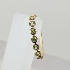 **KINDLY CHECK OUT THE VIDEO OF THE ITEM FOR A CLEARER VIEW**Details of the ring Gem: Peridot Gem size: 2 mm (9 pec ) Gem shape-Round Gem weight: 0.28 carats Gold purity: 14KT (58.33% approx.) Gold weight: 0.77 gms total weight of ring:0.83 gms Emerald cut Peridot gemstones set in solid 14KT yellow gold. The Gold purity is guaranteed and it comes with authentic 14 kt gold hallmark. Since these Rings are handmade, Size Customization is available for this ring and it is available in all ring sizes Fine Jewelry Peridot Ring For Wedding, Fine Jewelry Peridot Wedding Ring, Gold Peridot Jewelry With Gemstone, Classic Peridot Ring Jewelry, Heirloom Peridot Gold Rings, Peridot Ring Gold, Gold Peridot Ring, Birthstone Wedding Ring, August Birthstone Ring