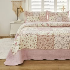 a pink and white quilted bed in a bedroom