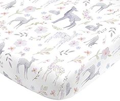 a baby crib sheet with deers and flowers on the sheets, in white