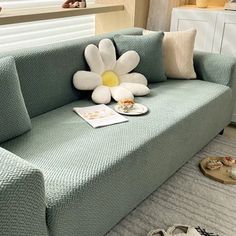 a couch with a flower on it in a living room next to a dog bed