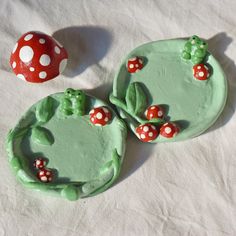 two cookies with green icing and red mushrooms on them