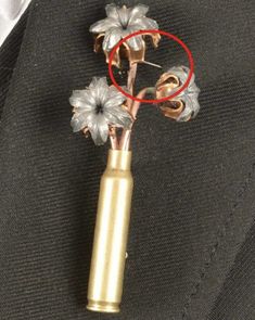 a close up of a metal object with flowers in it's lapel pin