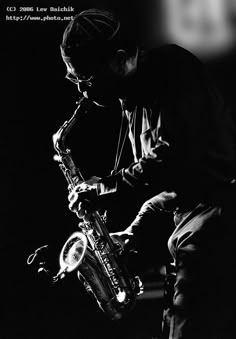 a black and white photo of a man playing the saxophone