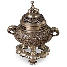 an ornately decorated silver teapot on a white background