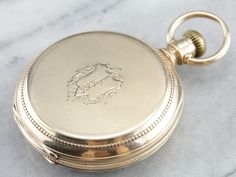 "This antique size 16 pocket watch was made by the Elgin watch company of Chicago in the year 1880. Edged with an outer dial and classic times new roman numerals, this piece features a second counting dial as well. The face of this piece is crisp white, the dials clear and the anodized hands have retained a sleek blue hue. The reverse of the case is engraved with a handsome monogram, the inside of the case is fitted with a secondary lid in the locket style, which has not been engraved and could Luxury Antique Pocket Watch With Polished Finish, Luxury Vintage Pocket Watch For Anniversary, Luxury Vintage Watches With Box Clasp, Engraved Yellow Gold Pocket Watch With Round Dial, Victorian Yellow Gold Pocket Watch With Chronometer, Timeless Self-winding Pocket Watch With Round Dial, Elegant Self-winding Pocket Watch With Round Dial, Elegant Self-winding Pocket Watch, Victorian Engraved Watch With Round Dial