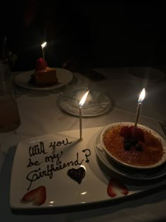 a birthday cake with two candles on it and someone's name written on the plate