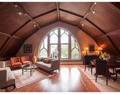 a living room filled with furniture and a large arched window in the middle of it