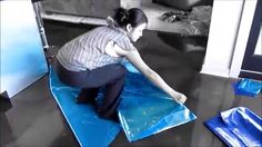 a woman sitting on top of a blue mat with her hand on the ground next to it