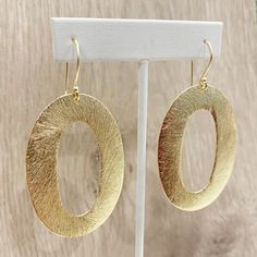 "These handcrafted earrings are modern and chic! Large gold circular hoops measuring over 2 inches long by 1.5 inches wide dangle from matching fish hooks. Earring material is brass dipped in brushed gold and lacquered with a protective varnish to prevent tarnish. Such beautiful texture! The earrings measure approximately 2.75\" in total length. A fabulous chunky look in a super lightweight style! Item is carefully packaged and shipped via USPS in a sturdy protective mailer. Check out more fabul Modern Gold Open Circle Earrings, Chic Hammered Metal Earrings, Modern Oval Earrings With Ear Wire, Modern Oval Metal Earrings, Modern Yellow Gold Hoop Earrings, Modern Small Hoop Hammered Earrings, Modern Circular Earrings For Party, Modern Hammered Circle Earrings, Modern Hammered Small Hoop Earrings