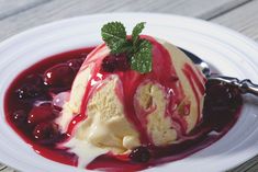 an ice cream sundae with cherries and mint sprig on top, served in a white bowl