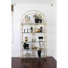 a shelf filled with vases and other items on top of a hard wood floor