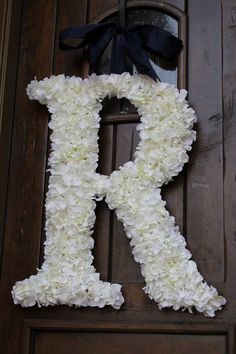 the letter r is made out of flowers and tied with a black bow on it