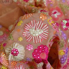 a close up view of a fabric with flowers on it and sequins in the center