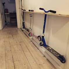 three scooters are lined up against the wall