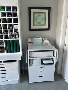 a white desk with drawers and an ironing board next to it in a room